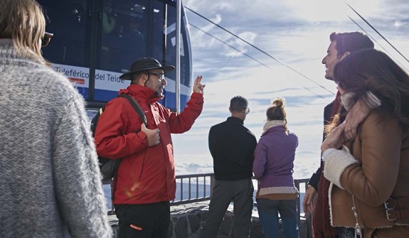 Paar beobachtet das Schauspiel des Teide-Schattens von einem Terrassen-Aussichtspunkt, nach der Bergfahrt mit der Seilbahn